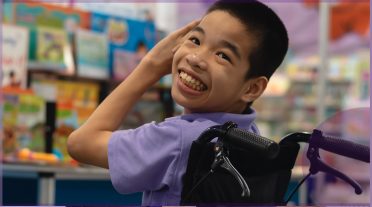 boy in a wheelchair in a mauve tshirt