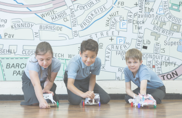 Students playing with model cars