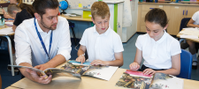 male teacher with a girl and a boy in classroom