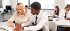 female teacher with boy of colour in a classroom