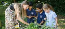 teacher with 2 children in a garden
