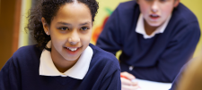 School girl with pencil at desk