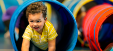 child crawling through a blue tunnel