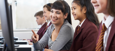 Pupil with teacher in front of monitor 