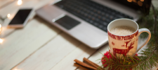 Christmas themed coffee cup in front of laptop