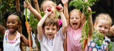 How does your garden grow? A love letter to the joy of gardening with young children Happy Early Years children brandishing plants