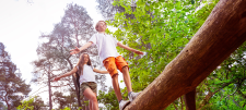 Girl and boy balancing on log