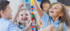 Happy class children building blocks together