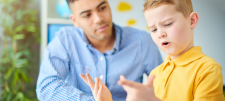 Adult with child in yellow shirt counting on both hands