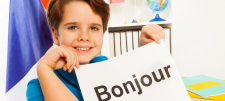 Person holding a sign which says "Bonjour"