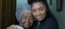Younger person holding an older person both of African heritage 