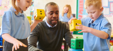 Teacher with students who are playing with extra large dice