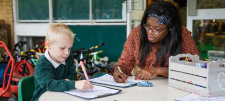 teacher with boy in green uniform