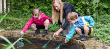 2 boys and a teacher playing with a pond