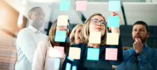 people looking at post it notes on a screen