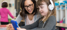 teacher with a young girl with headphones on