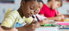 Girl writing in book with pencil