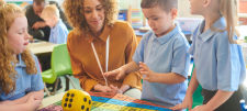 children with teacher and dice