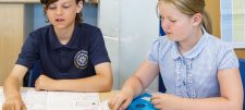 primary girl and boy sitting at a desk together