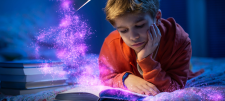 Purple mist coming out of open book as child looks on