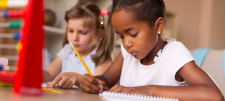 Girl writing in book with pencil