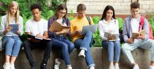 group of young people sitting on a wall