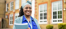 woman of colour in front of a school