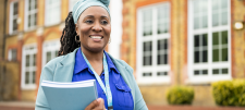 woman of colour in front of a school