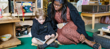 Educator sat with child on floor