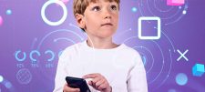 Child holding his finger near to a phone on a purple background