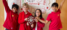 Happy children holding a trophy together