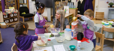 Adult with Early Years children sat round a table 