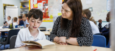 Adult with young learner, reading a book together