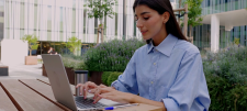 Woman in blue shirt typing on laptop