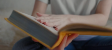 Using World Book Day as a springboard to re-ignite reading for pleasure Hand on open yellow book