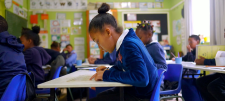 Divide and conquer! Working towards teaching formal written division in Key Stage 2 Girl in blue school uniform in a classroom