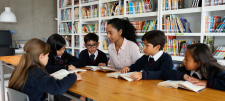 Strong foundations for reading fluency Teacher with students at a large table, all with open books infront of them