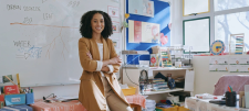 Woman sat on desk with her arms folded