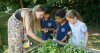 teacher with 2 children in a garden
