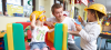 man with 2 young children in playground
