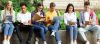 group of young people sitting on a wall