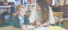 Child and teacher sitting at desk