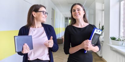 2 women walking along a corridor together