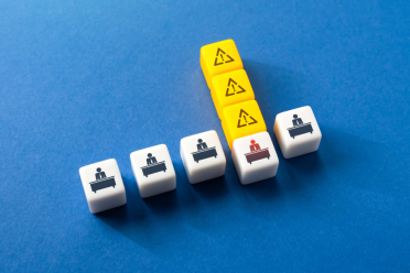 Icons of office worker and warning signs on white cubes on blue background