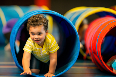 Child crawling through play tunnel 