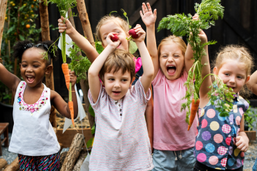 Happy children brandishing vegetables 