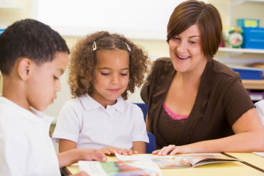 Teacher helping junior school children 